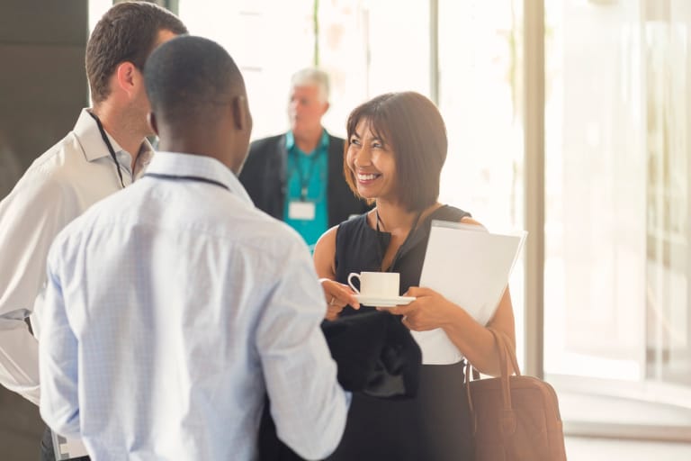 Three business professionals engaged in conversation